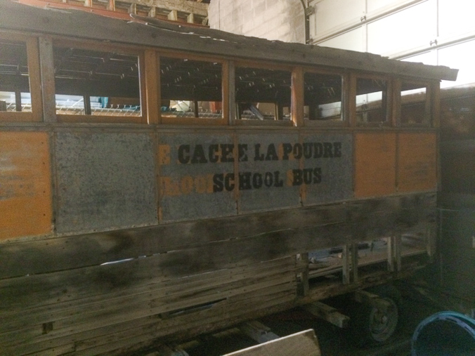 A side view of the "Cache la Poudre School Bus" in the Fort Collins Municipal trolley barn.