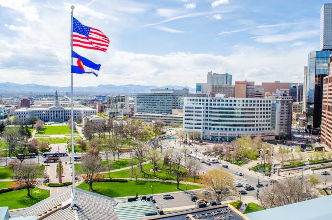 The flags cooperated as I snapped a photo of the city building and the rounded Denver Post building. 16th Street Mall can be seen on the far right.